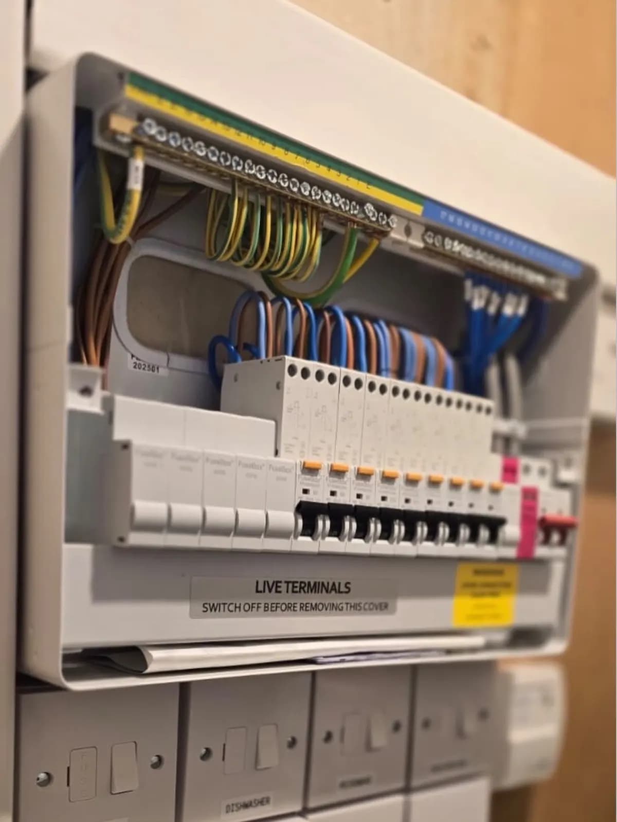 Inside of a new consumer unit during installation in Reigate, showing neat wiring to each breaker